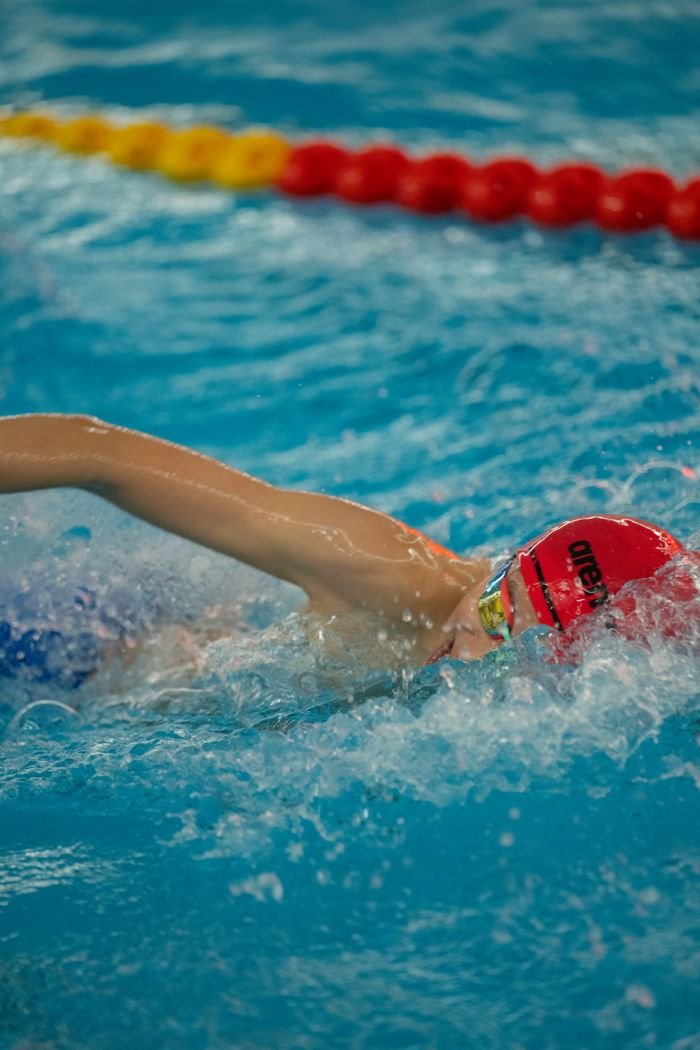 Freestyle swimmer in action at a swim meet, showcasing athleticism and speed.